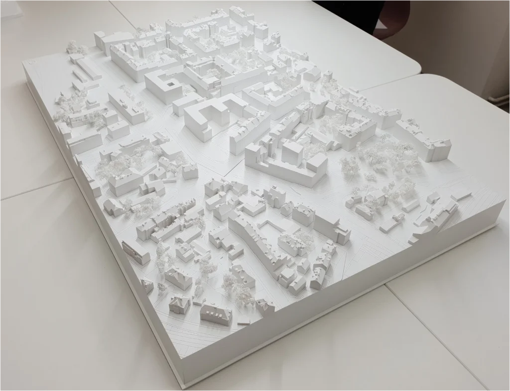 Weißes Umgebungsmodell eines Stadtquartiers mit dichter Blockbebauung, Straßenstruktur und Baumbestand – städtebauliches Architekturmodell