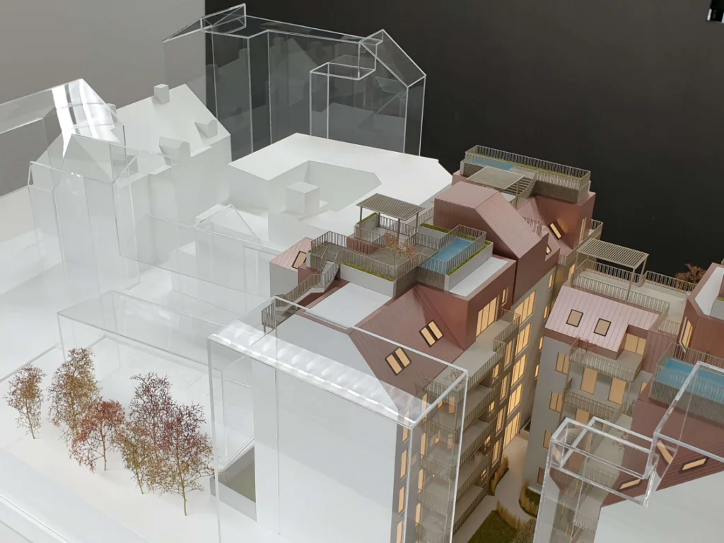 Immobilienmodell mit beleuchteter Wohnbebauung und transparent dargestellten Umgebungsgebäuden, Dachterrassen und Volumen zur Analyse der städtebaulichen Einbindung