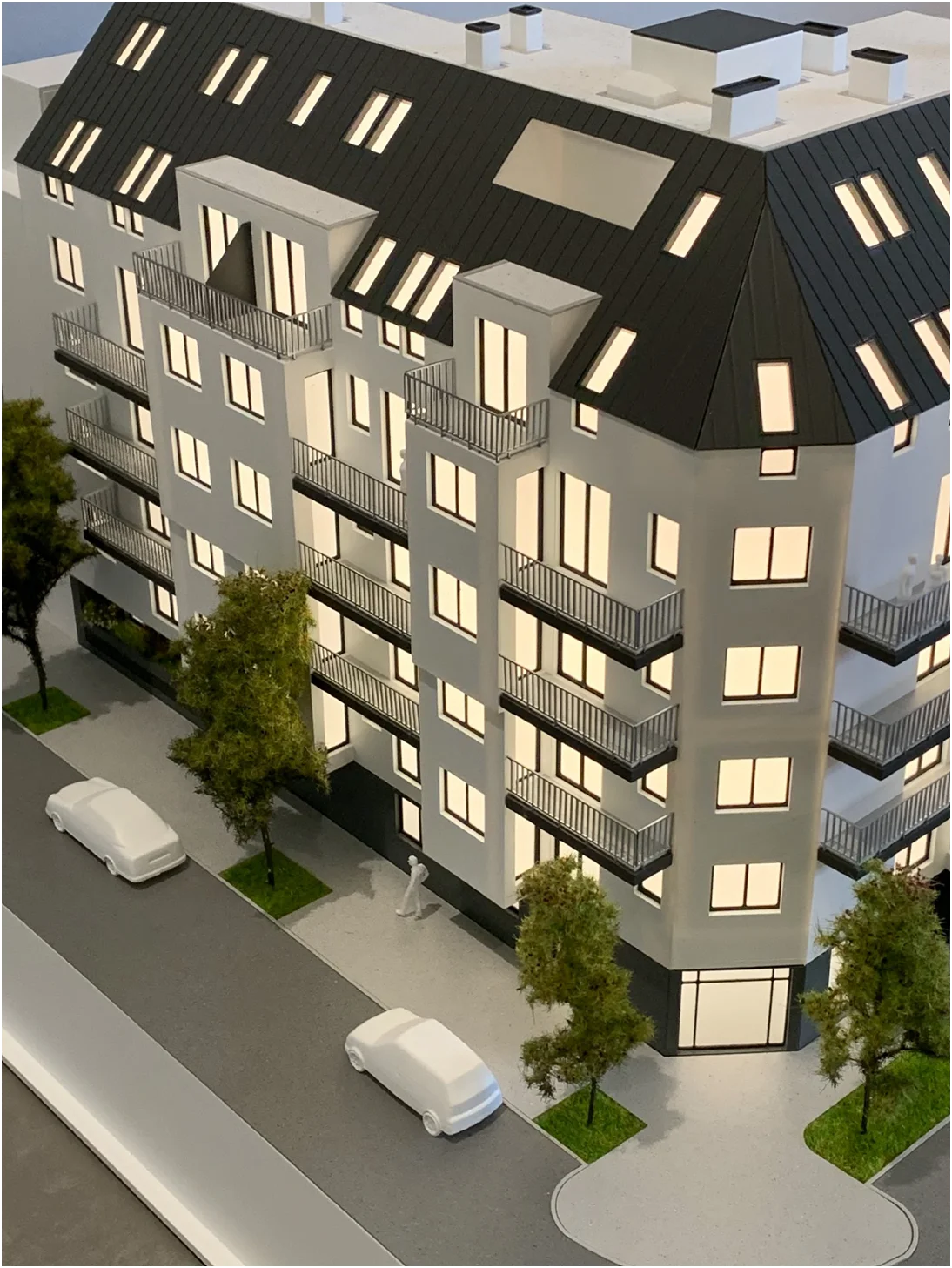 Immobilienmodell im Maßstab 1:100 – detailliertes Architekturmodell eines Wohngebäudes mit Balkonen, Beleuchtung und Stadtumfeld
