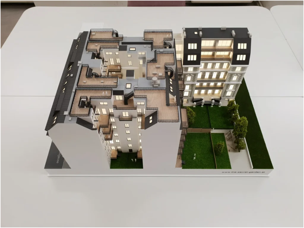 Wohnbau-Immobilienmodell im Maßstab 1:100 – Präsentationsmodell für Neubauprojekte mit Innenhof und Grünflächen
