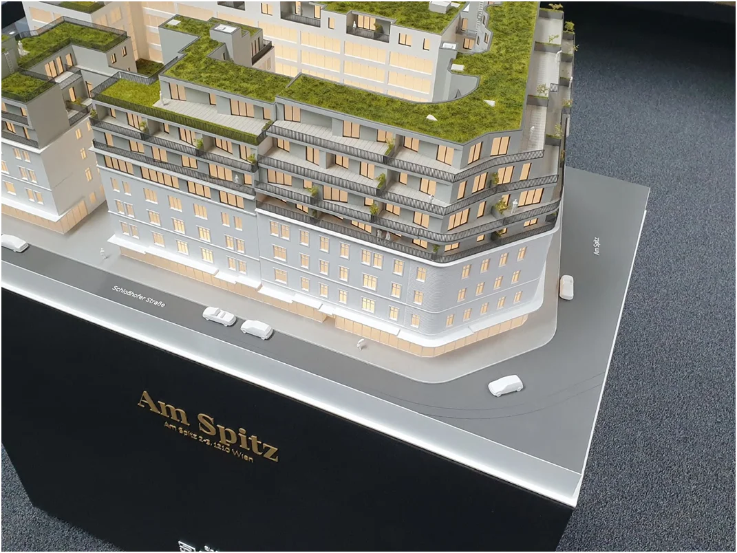 Immobilienmodell im Maßstab 1:100 – Architekturmodell eines Wohnbauprojekts mit Innenhof, Dachterrassen und Grünflächen
