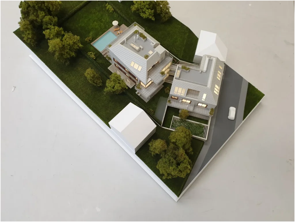 Immobilienmodell moderner Wohnhäuser mit Gartenanlage und Pool – Architekturmodell eines exklusiven Neubauprojekts
