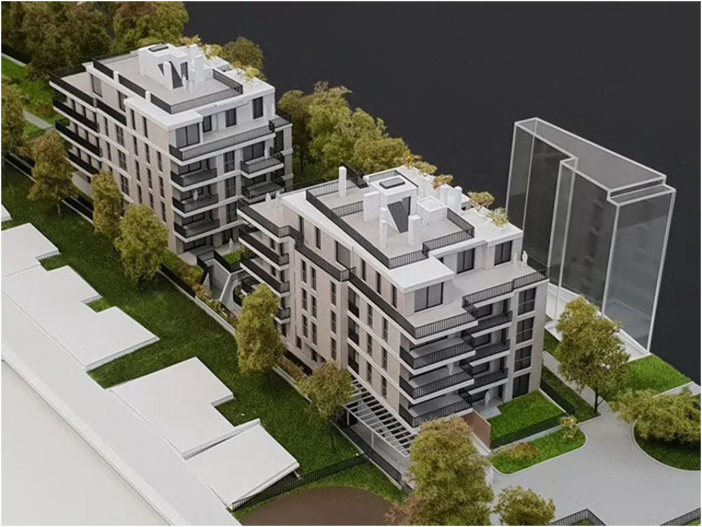Architekturmodell einer modernen Neubau-Wohnanlage im Maßstab 1:100 mit zwei Wohngebäuden, Balkonen und Grünanlagen
