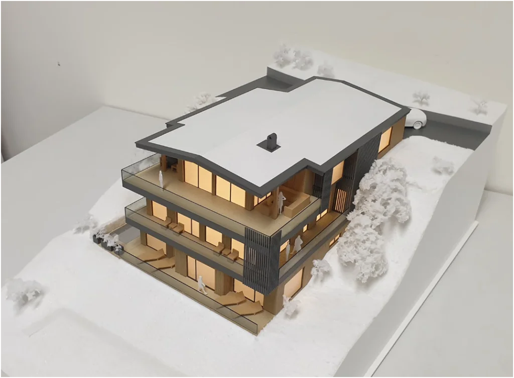 Architekturmodell eines modernen Neubau-Wohnhauses im Maßstab 1:100 mit Terrassen, großen Glasflächen und Winterlandschaft
