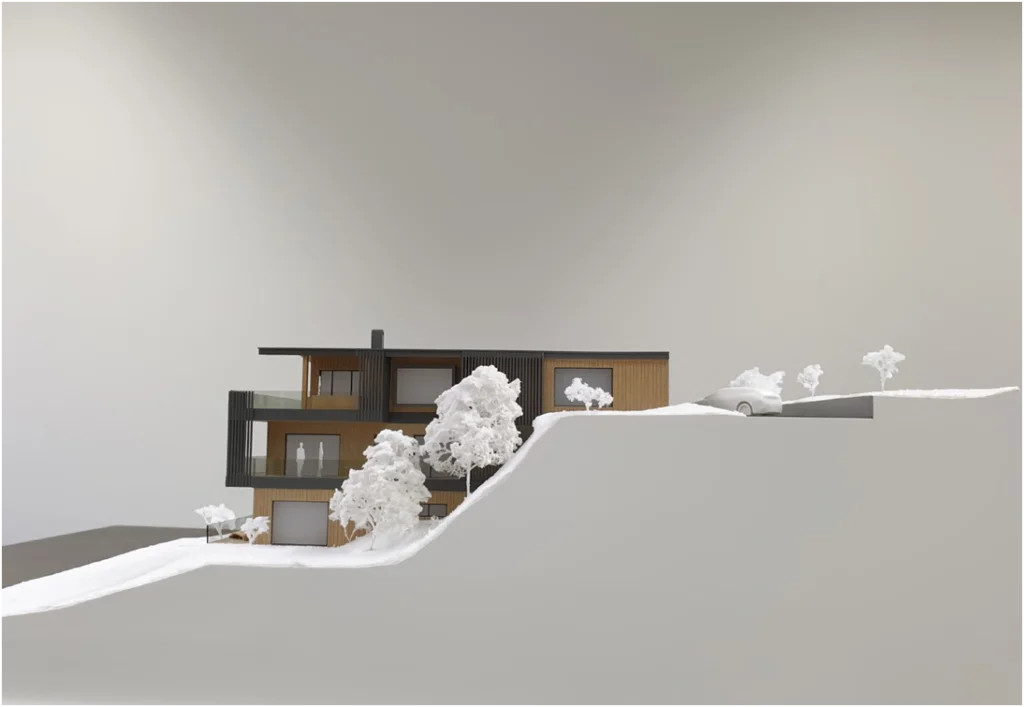 Architekturmodell eines modernen Neubau-Wohnhauses im Maßstab 1:100 am Hanggrundstück mit Terrassen und reduzierter Landschaftsgestaltung
