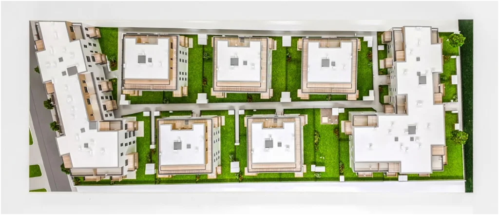 Vogelperspektive auf ein Quartiersmodell eines Wohnprojekts mit mehreren Gebäuden, vollfarbiges Architekturmodell mit Grünflächen und Innenhöf