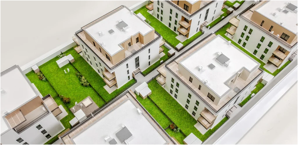 Detailansicht eines Quartiersmodells mit mehreren Wohngebäuden, vollfarbiges Architekturmodell mit Grünflächen, Wegen und Innenhöfen
