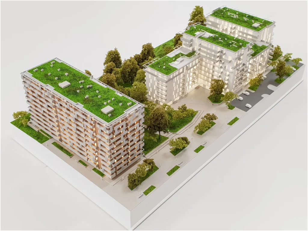 Quartiersmodell eines Wohnprojekts mit mehreren Gebäuden und begrünten Dachflächen, vollfarbiges Architekturmodell mit Außenanlagen und Wegen