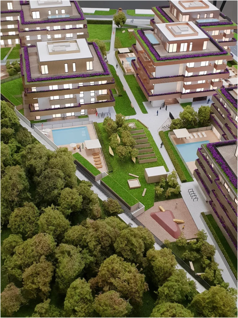 Vogelperspektive auf ein Quartiersmodell eines Wohnprojekts mit mehreren Gebäuden, Architekturmodell mit großzügigen Grünflächen, Spiel- und Erholungszonen