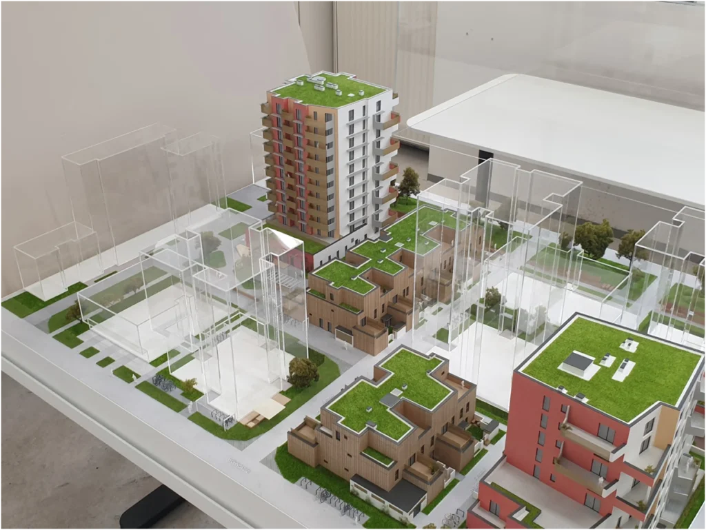 Kombiniertes Quartiersmodell eines Wohnprojekts mit mehreren Gebäuden, Architekturmodell mit transparenter Volumenstudie und vollfarbig ausgeführten Baukörpern