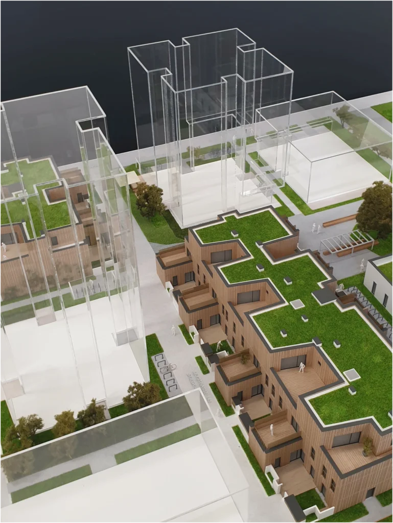 Kombiniertes Quartiersmodell eines Wohnprojekts mit mehreren Gebäuden, Architekturmodell mit transparenter Volumenstudie und detaillierten Wohnhäusern mit begrünten Dächern