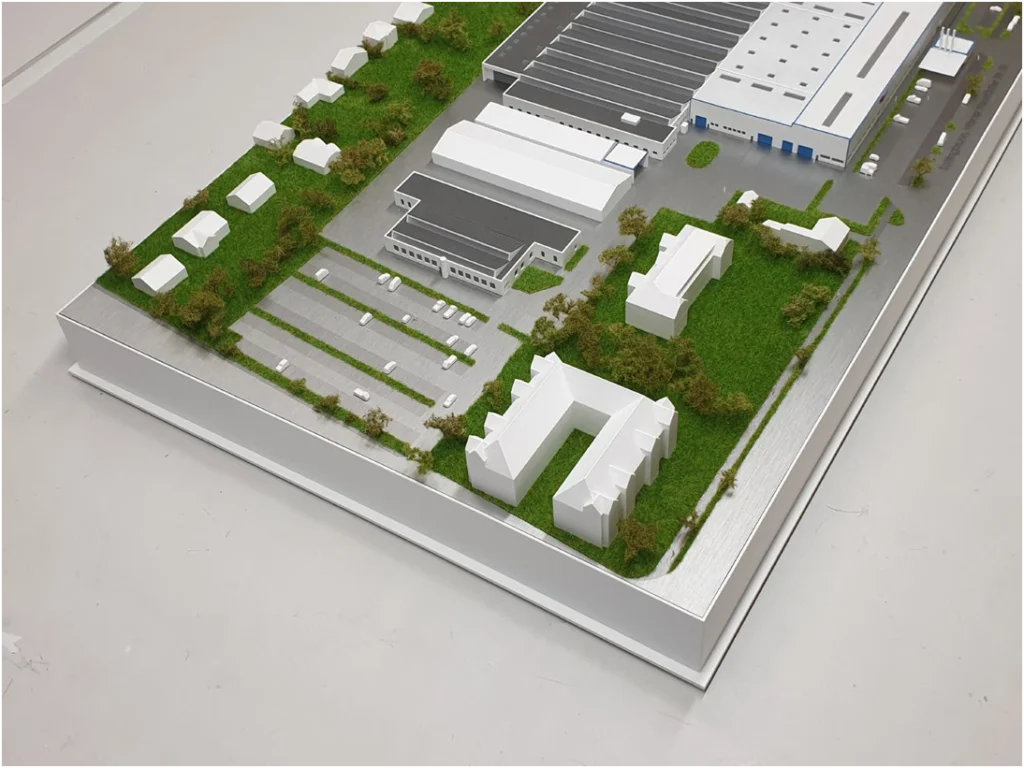 Industriearchitekturmodell eines Logistik- und Gewerbeareals mit Hallen, Parkflächen und angrenzender Bebauung.
