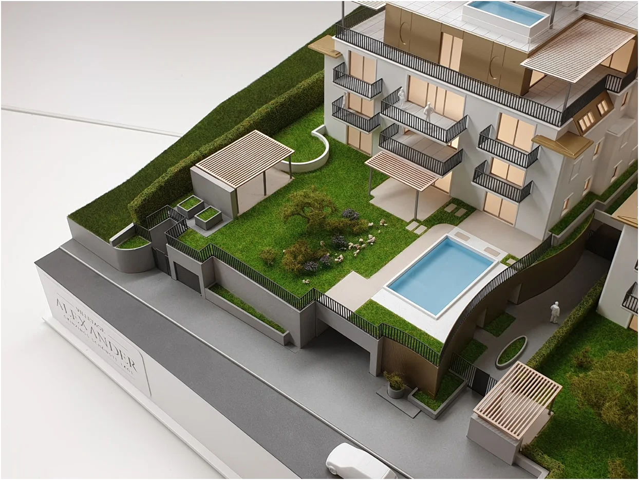 Architekturmodell mit hochwertiger Freiraumgestaltung, Innenhof mit Grünflächen, Pool und Landschaftselementen, vollfarbige Ausführung im Immobilienmodell