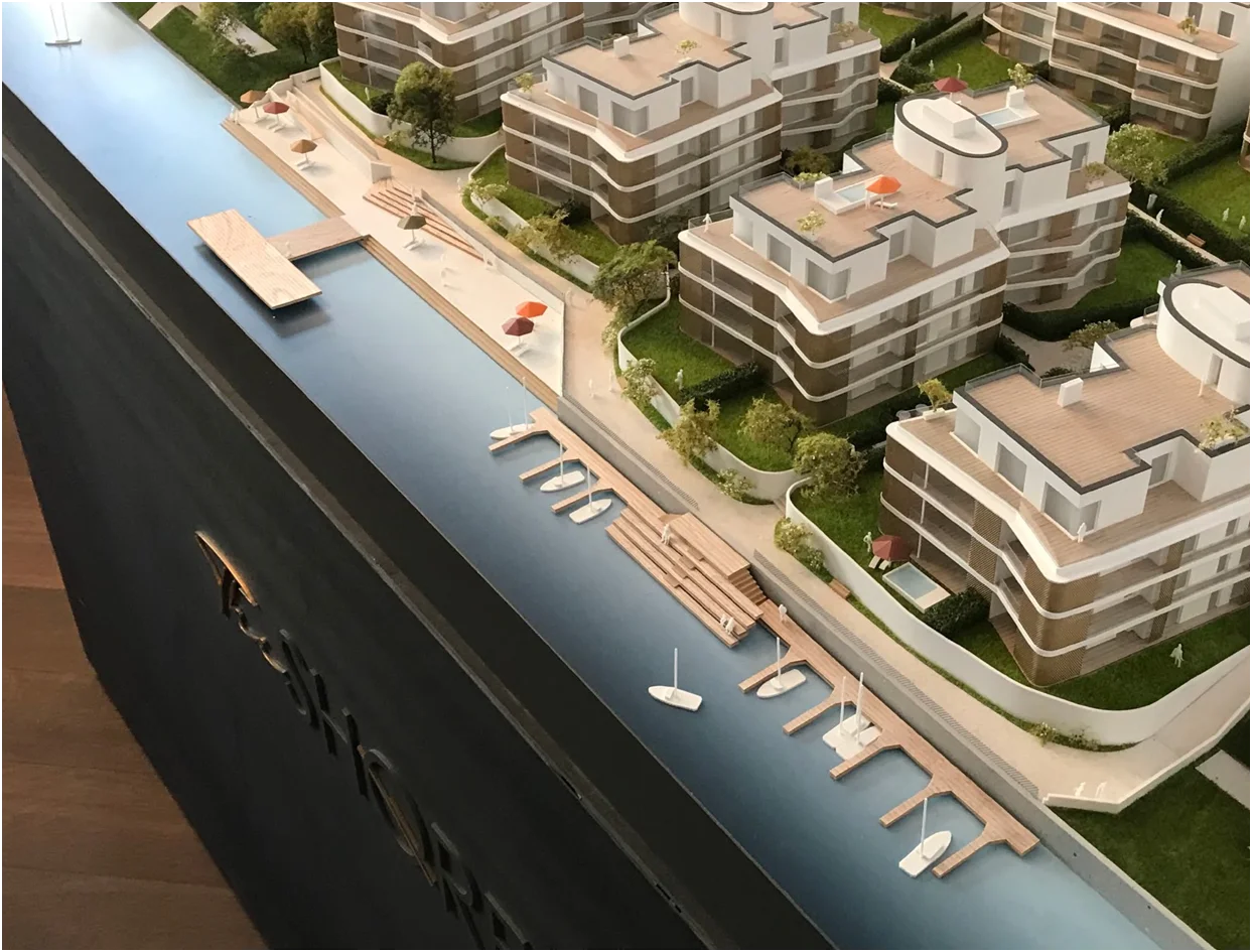 Architekturmodell eines Wohnensembles mit Wasserlage, Steganlagen, Freiraumgestaltung und Landschaftselementen, vollfarbige Darstellung eines Immobilienprojekts