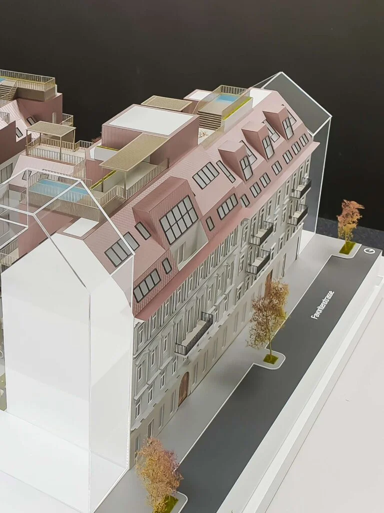 Architekturmodell Quartier Starhemberg: Detailansicht der Fassade mit beleuchteten Fenstern und Mansarddach im Maßstab 1:75.