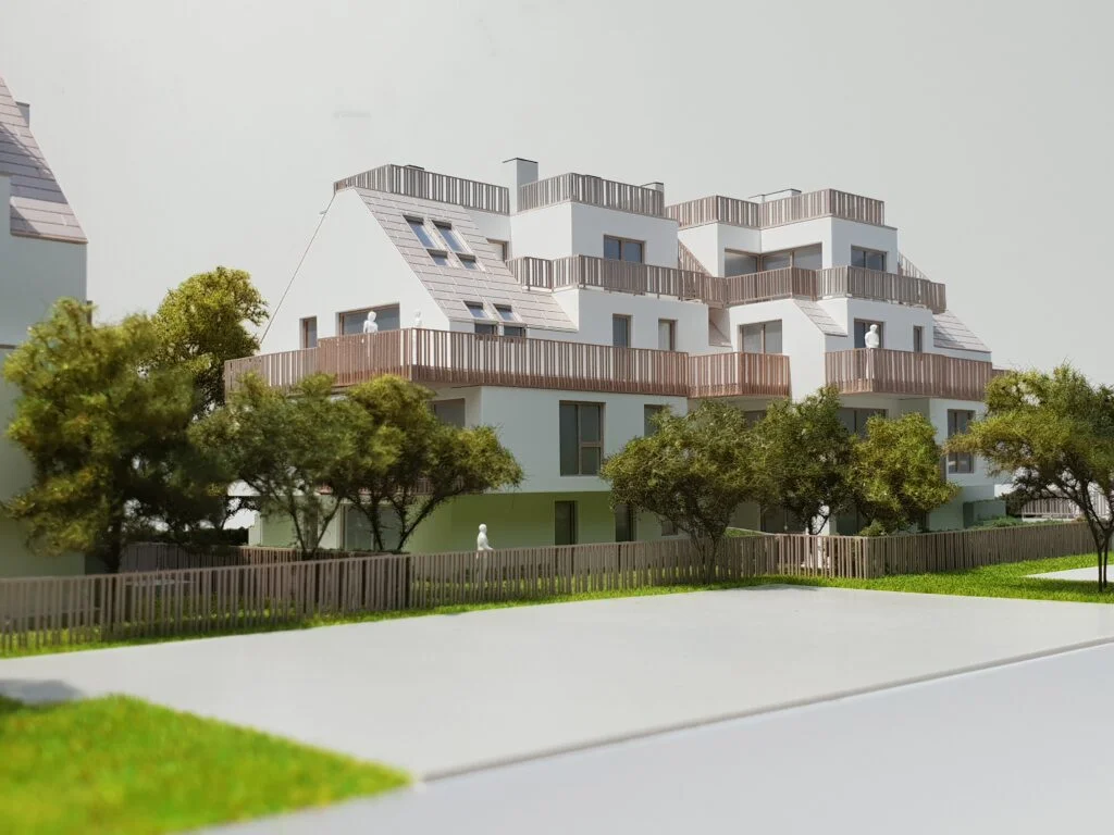 Moderne Wohnanlage mit terrassierten Balkonen, hellen Fassaden und begrüntem Außenbereich – Architekturmodell